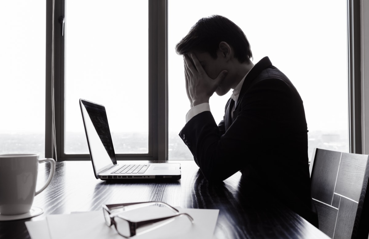 ノートパソコンの前で頭を抱える会社員